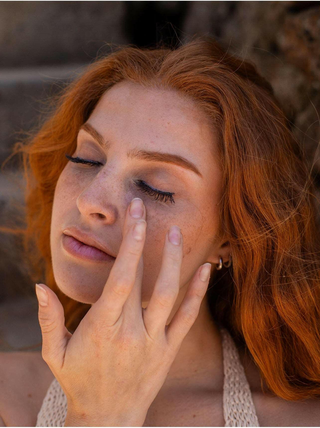 Model rubbing in Hydrating Eye Serum - an oil-free, transparent liquid that reduces dark circles and improves the firmness and tone of the delicate eye area. Our formula utilizes peptides and cucumber to tighten and firm the skin